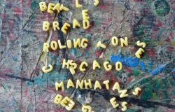 Trabalho de portador de sofrimento mental tem fundo colorido sob letras amarelas, soltas, que formam palavras como Beatles, bread, Roling Tones e Manhatan misturados a letras desconexas.