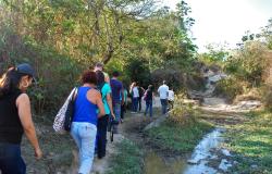 Agentes em treinamento caminham ao lado de um pequeno lago em área verde