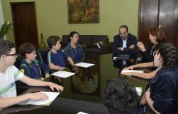 Prefeito Alexandre Kalil sentado à mesa com estudantes