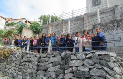 Grupo de crianças em frente a muro de pedras