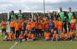 Alunos da Escola Municipal Itamar Franco posam ao lado de goleiros do América, time de futebol de Belo Horizonte