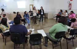 Treze pessoas reunidas, sentadas em círculo, para as atividades do Encontro das Famílias.