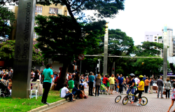 Mais de quinze pessoas na Savassi, umas a pé e outras de bicicleta. 