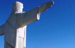 Imagem do Cristo do Barreiro de costas. Ao fundo, céu azul em dia claro.