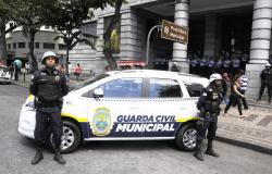 Dois guardas municipais à frente de carro da nova frota em frente à Prefeitura de BH.
