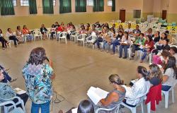 Mais de 50 pessoas reunidas, sentadas, em círculo, uma mulher, de costas, fala ao microfone. Imagem ilustrativa de edição anterior de Pré-Conferência de Políticas sobre Drogas na Regional Noroeste.