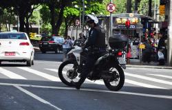Guarda Municipal em moto no meio do trafego da cidade realizando o ser trabalho.