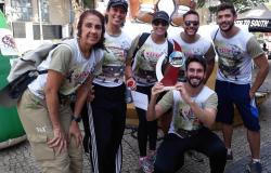 Três servidoras e três servidores posam para foto com o troféu nas mãos de um deles.