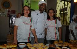Duas alunas do Programa Pão Escola posam ao lado de professor. Foto ilustrativa.