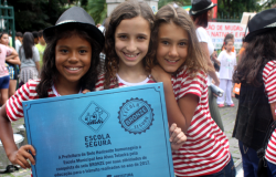 Três alunas seguram certificado Escola Segura.