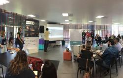 Homem dando palestra e mais de vinte pessoas assistindo em evento Hack a City