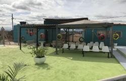 Contêineres onde funcionará o anexo do Centro de Saúde Dandara, com gramado verde e bancos