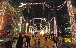 Luzes de Natal da Praça da liberdade e cidadãos andando na praça, alguns deles com guarda-chuva. Foto ilustrativa, do Natal de 2016.