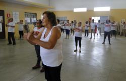 Mais de vinte integrantes do Grupo de Atividades físicas fazendo ginástica.